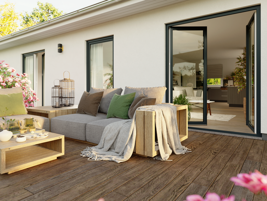 Terrasse des ERA 131 mit geöffneter Tür und Blick auf den hellen Wohn- und Essbereich mit Küche